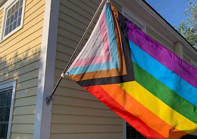 Pride flag hanging outside a house.